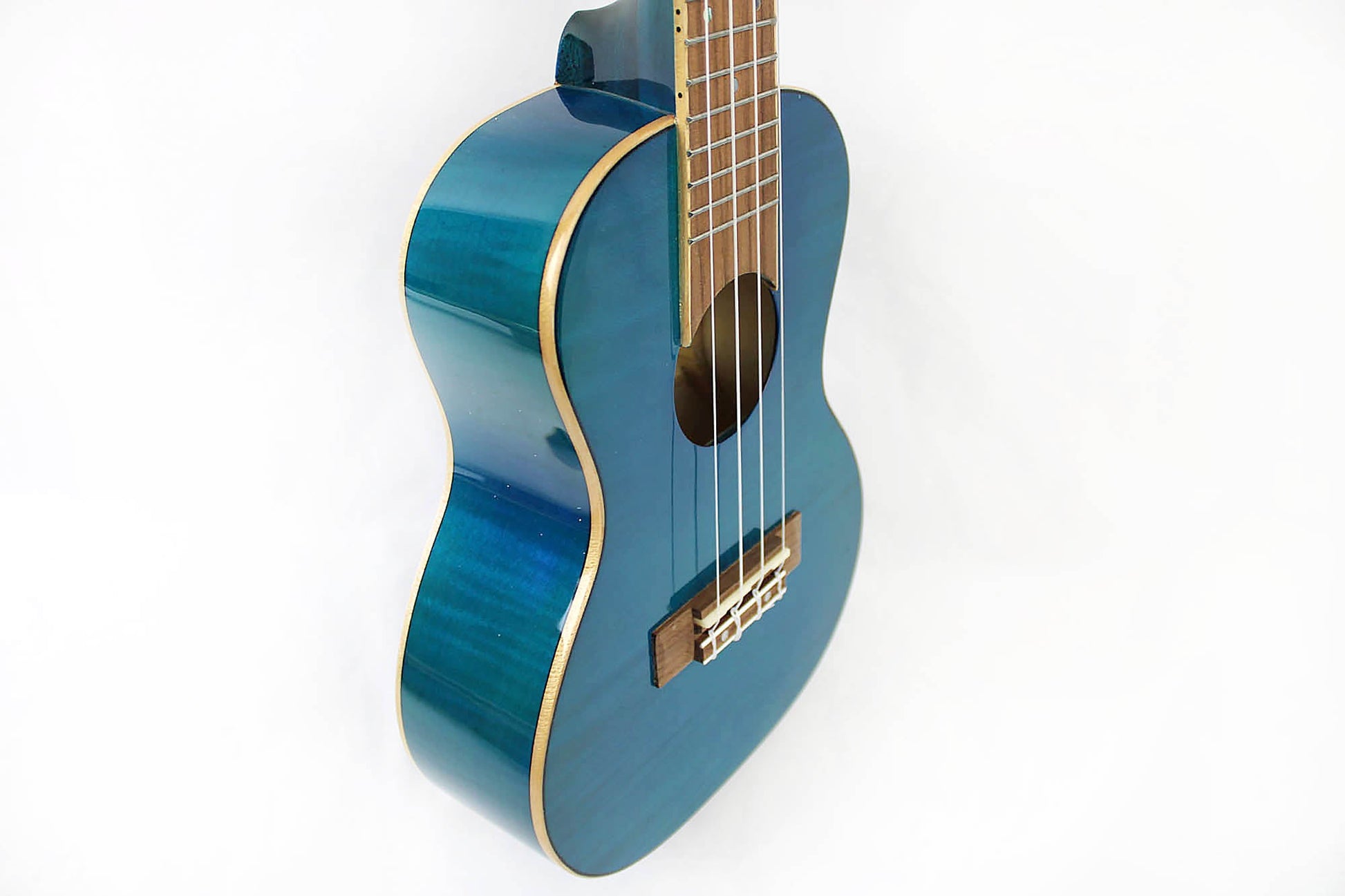 This is the front side view  of the top and neck of an Amahi PGUK555BLC Flamed Maple Concert Ukulele- blue.
